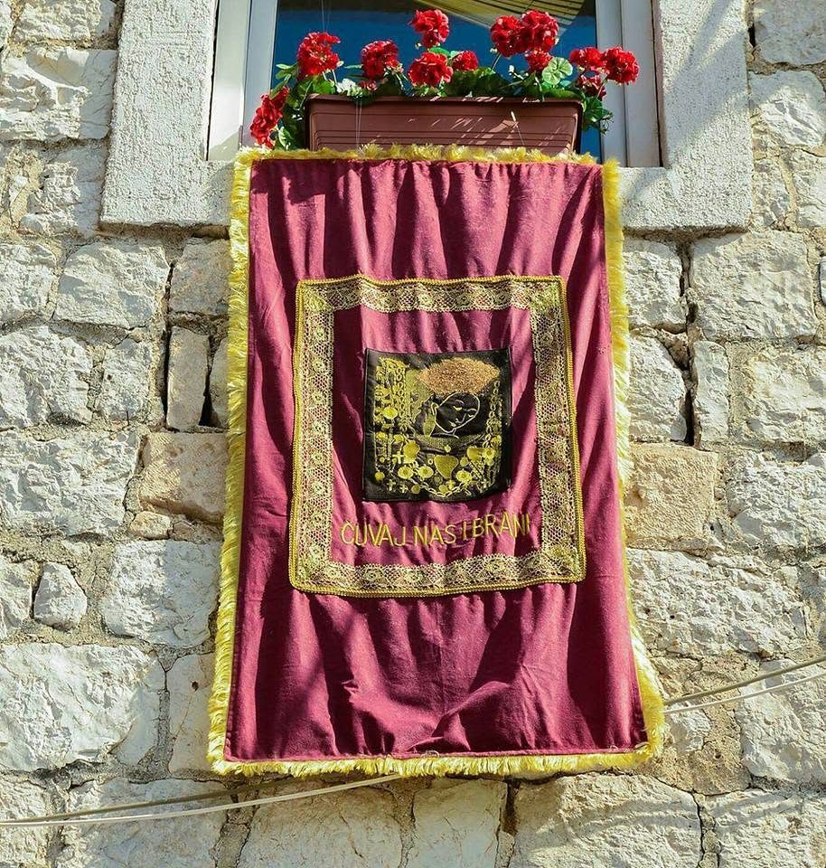 Vezeni crkveni tekstil na fasadi, natpis Čuvaj nas i brani